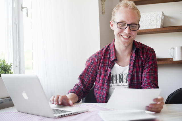 Mann sitter foran Mac'en sin og planlegger et nytt bad